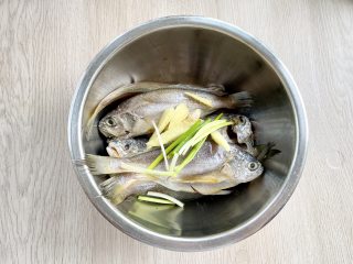 空气炸锅版香酥小黄花鱼，少油更健康，外焦里嫩还解馋,把小黄花鱼放入盆中，加入姜片和葱段