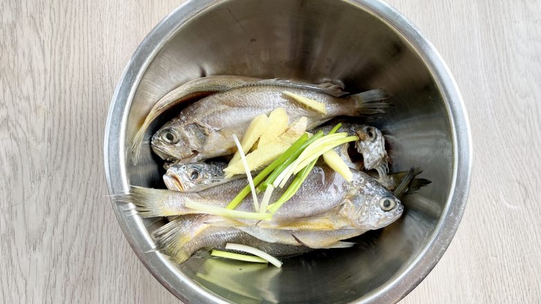 空气炸锅版香酥小黄花鱼，少油更健康，外焦里嫩还解馋,把小黄花鱼放入盆中，加入姜片和葱段