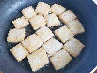 砂锅香菇豆腐煲,锅中热油，放入豆腐煎至金黄色后盛出。