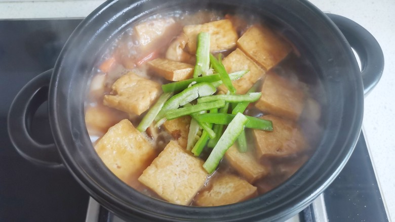 砂锅香菇豆腐煲,加入青椒翻炒入味即可。