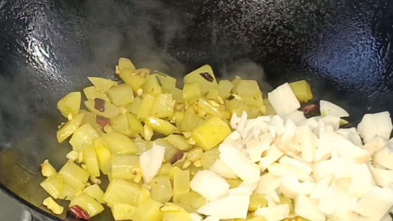 酸辣土豆藕丁,加入藕丁炒匀，淋入少许清水，炒匀至断生