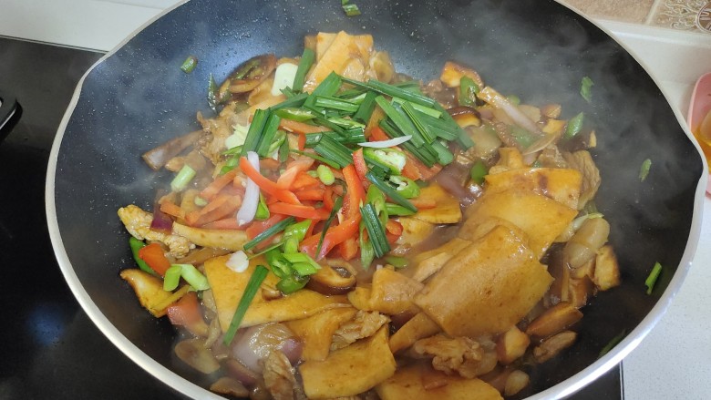 干锅千叶豆腐,加入蒜叶和红椒丝翻炒至断生