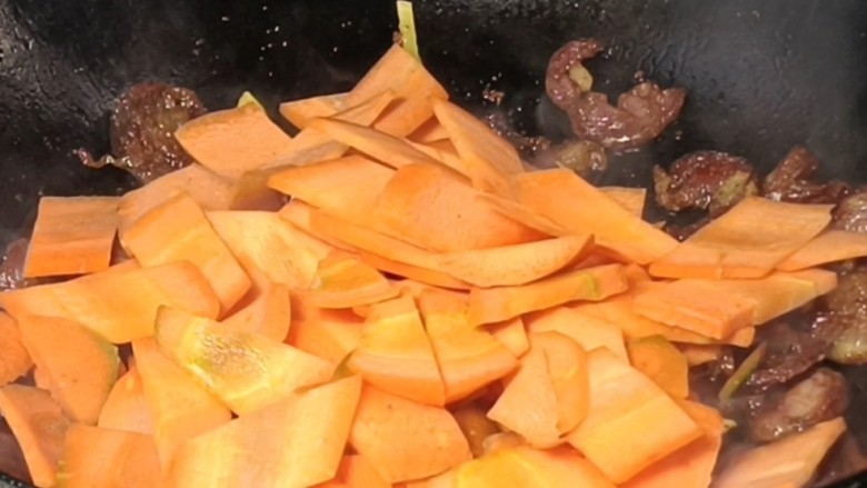 胡萝卜炒香肠,加入胡萝卜炒匀，加少许清水，盖上盖子焖3分钟
