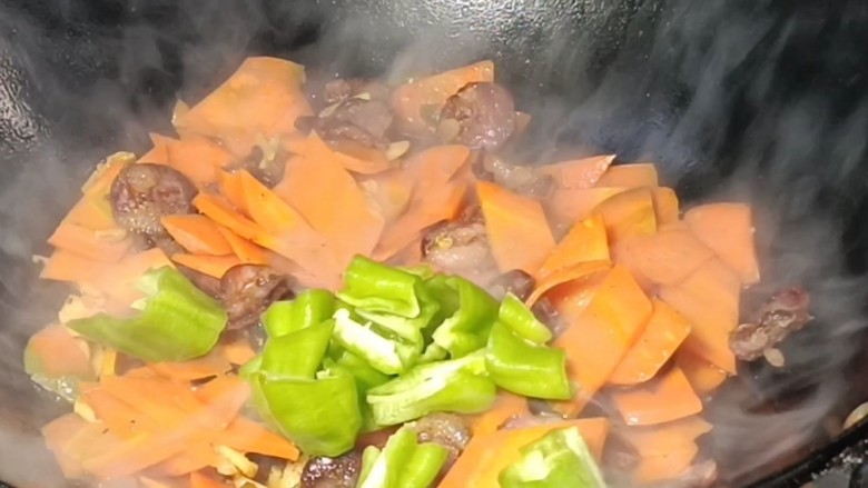 胡萝卜炒香肠,打开锅盖，放入青椒炒匀至断生