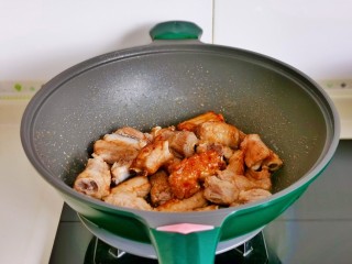 话梅排骨,起油锅加冰糖炒至褐色+排骨翻炒。