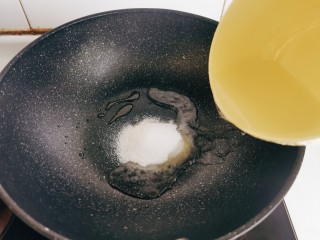 话梅排骨,空锅里倒入20克白糖，加入少许清水，一边搅拌一边翻炒