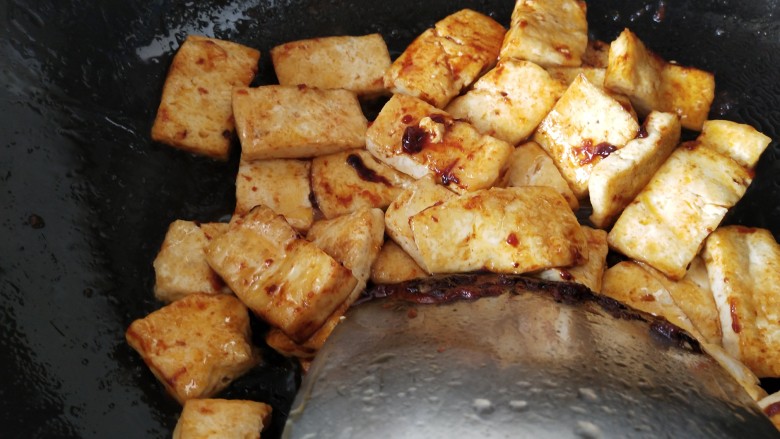 韩式辣酱豆腐,放入豆腐，用铲子小心地翻炒，让每一片豆腐都能裹上酱汁