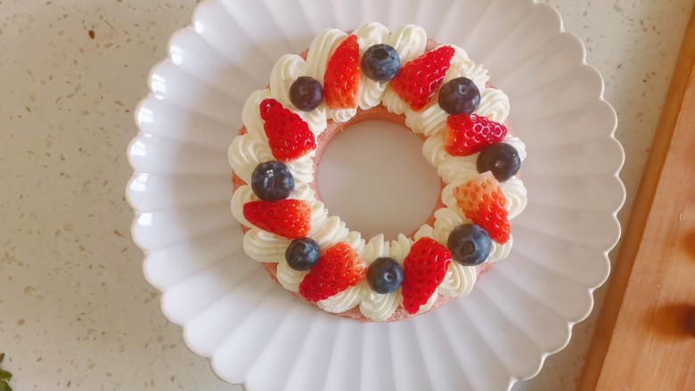 果子蛋糕,挤入一圈奶油，摆上草莓和蓝莓