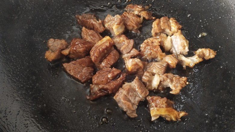 牛肉炖芋头,倒入牛肉翻炒，让每一块牛肉都能裹上冰糖