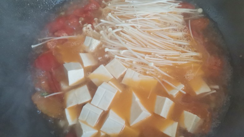金针菇番茄汤,水开下入金针菇，豆腐，继续煮