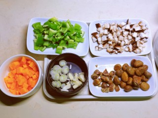 香菇板栗焖饭,板栗去壳，香菇、胡萝卜和青椒切丁，葱蒜切片备用。