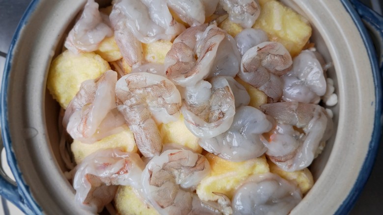 虾仁豆腐煲,将处理好的虾仁铺在豆腐上，再加入一碗高汤。