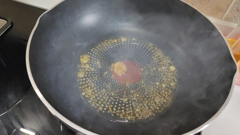 鹌鹑蛋红烧肉,锅中加入适量食用油，加入冰糖炒至起枣红色的大泡。