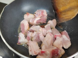 鹌鹑蛋红烧肉,加入五花肉翻炒至均匀上色。