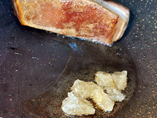 五花肉焖莲藕,猪皮是一定要煎焦的。炒冰糖（五花肉移至锅边即可）