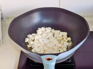 虾仁豆腐煲,起油锅加入蒜末煸炒，再加入豆腐。