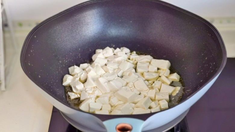 虾仁豆腐煲,起油锅加入蒜末煸炒，再加入豆腐。