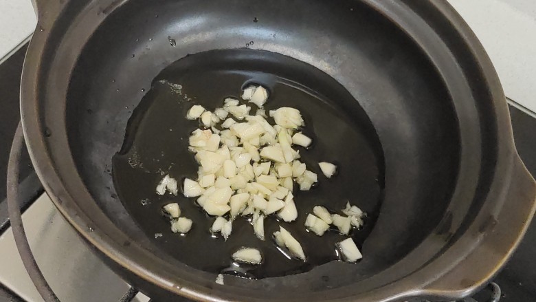 香菇板栗焖饭,锅中烧油，爆香蒜末。