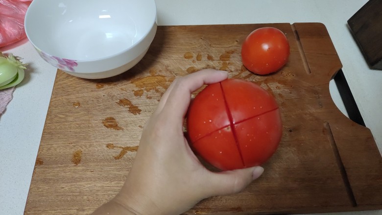 金针菇番茄汤,两个<a style='color:red;display:inline-block;' href='/shicai/ 3551'>西红柿</a>清洗干净，切上十字花刀。
