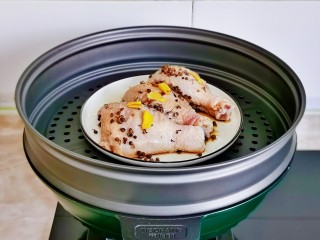 姜葱冬菇蒸滑鸡,装鸡腿盘子放蒸屉上。