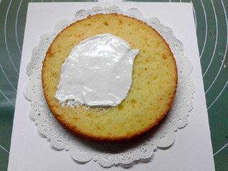 圣诞树蛋糕,取一片蛋糕，放在蛋糕托上，在表面抹满奶油。
