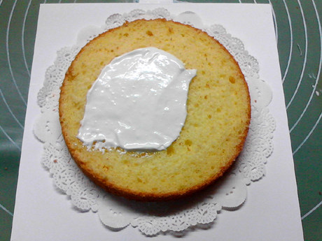圣诞树蛋糕,取一片蛋糕，放在蛋糕托上，在表面抹满奶油。