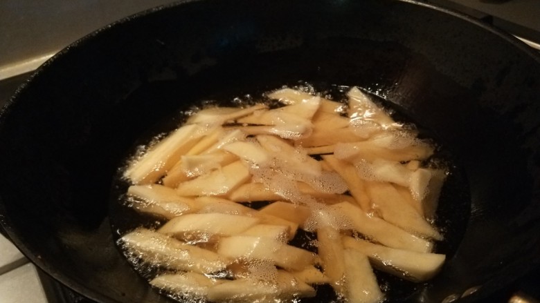 孜然煎豆干,锅中倒入适量油烧热倒入土豆
