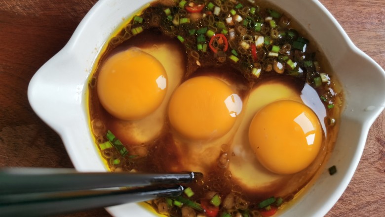 酱卧鸡蛋,用筷子轻轻的搅动，让部分蛋清和料汁混合，注意不要把蛋黄戳破。