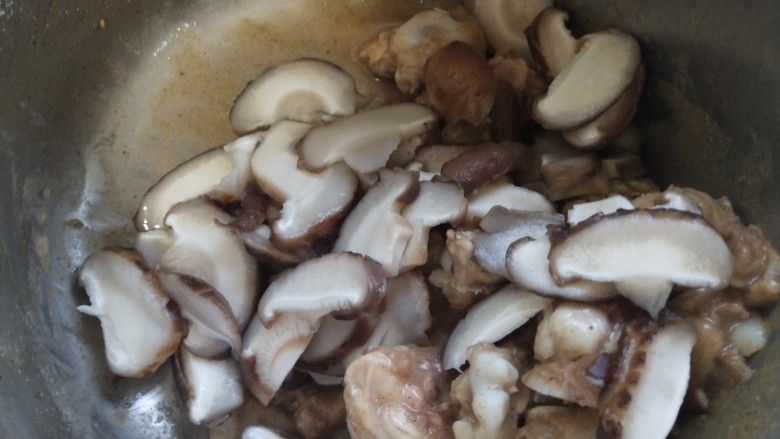 姜葱冬菇蒸滑鸡,把冬菇放入腌制好的鸡腿里拌匀