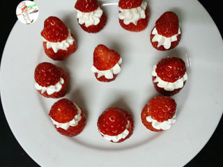 草莓雪人,再把刚切下来的小半颗草莓，盖在奶油上面，当做圣诞帽子