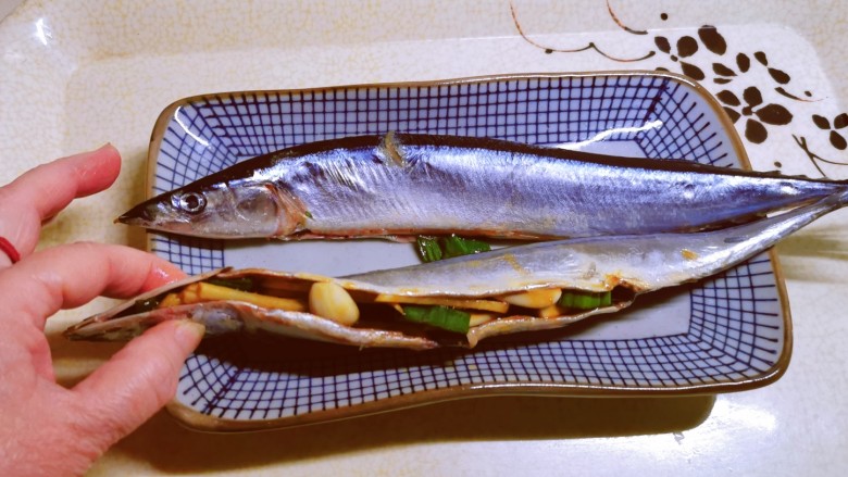 盐焗烤鱼,将调好的葱姜蒜装入鱼肚子里面。