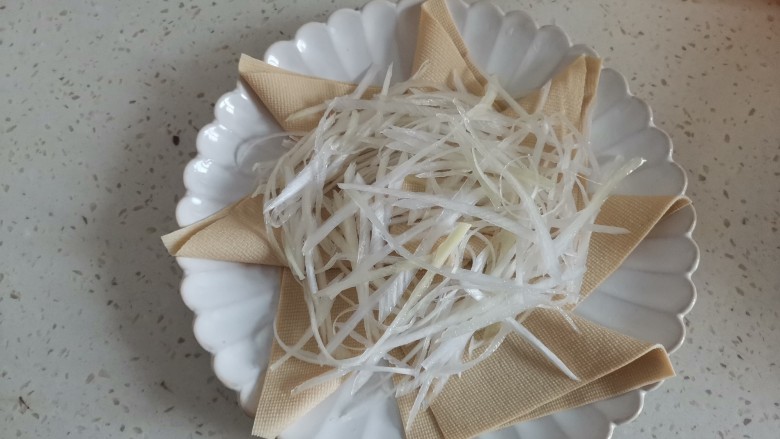 京葱炒肉丝,豆皮叠成三角形，摆放在盘子里，把京葱切成丝，放在中间