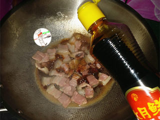 咸肉炒大蒜,稍后淋入少许红烧酱油，炒匀，给肉片上色