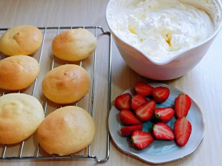 草莓抱抱卷,草莓洗干净，从中间切开，蛋糕片放烤网上晾凉，把打发的奶油装入裱花袋中。