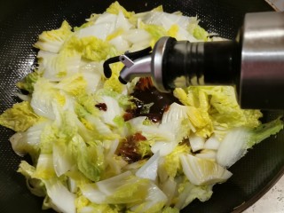 白菜烩小酥肉,倒入黄豆酱和酱油提味。