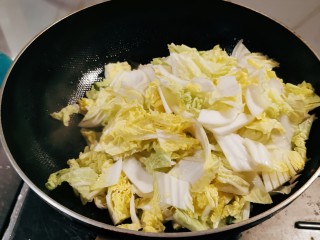 白菜烩小酥肉,白菜切块放入锅中翻炒。