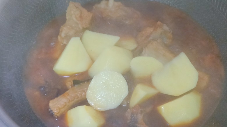 番茄烧排骨,加入土豆块，盖上锅盖中小火闷烧20分钟左右，7期间要注意水量以免烧糊