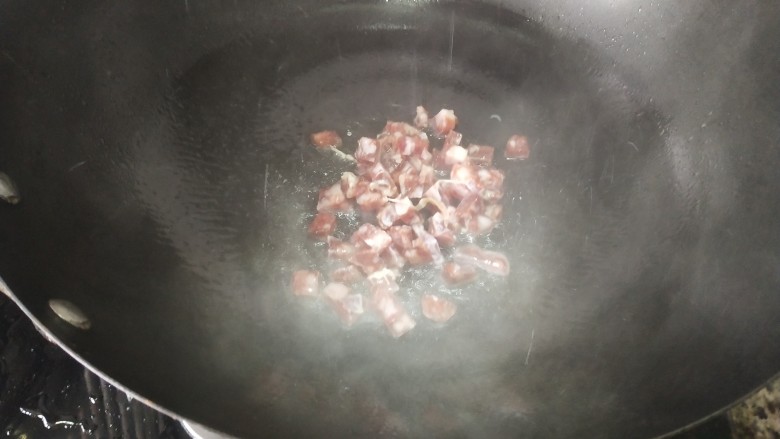 腊肠毛豆,锅里放油烧热，放入腊肠丁，小火慢炒