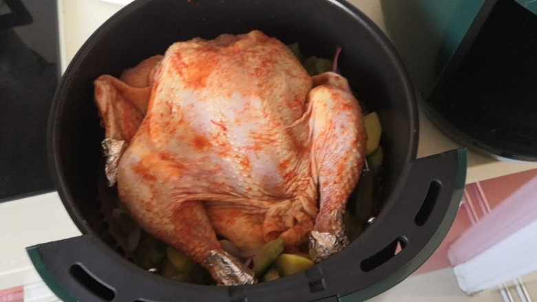 空气炸锅版手扒烤鸡,放入腌制好的整鸡，建议鸡翅尖和鸡腿根处用锡纸包下，防止烤焦。