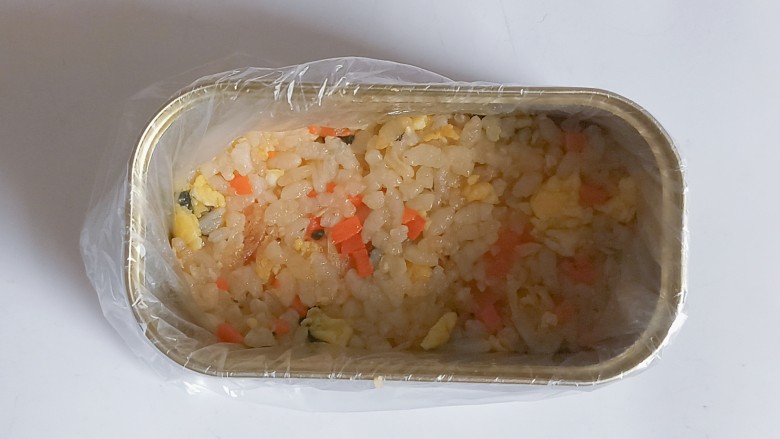 午餐肉饭团,午餐肉罐头里放一条保鲜袋，装入3勺米饭用勺子压一压
