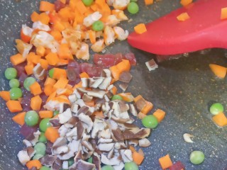 腊味糯米饭,再加入青豆，胡萝卜丁，香菇，虾干翻炒片刻