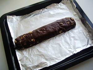 巧克力坚果意式脆饼,用刮刀切拌均匀，将面糊直接放在铺了烤盘纸的烤盘里，用手整形成长条状；