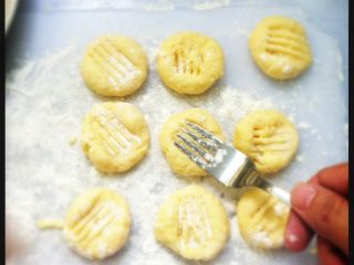 香煎薯饼,如图 压扁小球，并用叉子压出凹痕。