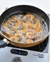 椒盐虾,锅中倒入油，大火加热至7成热，一只只的将虾放入油中炸至虾身变成橙红色，约2分钟左右，捞出后充分沥干油份。锅中的油倒出不用