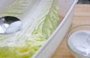 韩式辣白菜,将滤干水分的大白菜叶一片片的放入一个大的食品盒中，每放一片，都要在表面细细撒上一层盐，再放一片再撒盐，如此重复，直至所有的叶片都放入盒中。