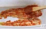 韩式辣白菜,取一片挤干水分的白菜，用刷子或手在正反两面均匀的涂抹上一层酱料，再放一片再涂，如此重复，直至涂完所有的白菜。