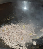 酸菜炒肉丝,倒入肉丝炒至变色后盛出备用。