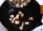 家常红烧肉,将五花肉放入，搅拌拌匀使每块肉都沾满焦糖色。