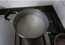 生滚鱼片粥,姜切丝，香葱切葱花；取一部分白粥加入汤锅，大火烧开后加入姜丝煮5分钟；期间适时用蛋抽使劲搅拌，将大米粒打碎并打出米油；