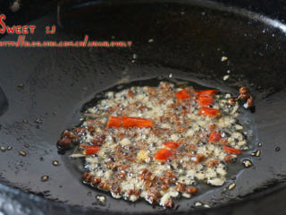 香辣刁子鱼,锅中留比平时炒菜，稍微多些的油，下姜蒜末和花椒以及干红椒碎，中火爆香。